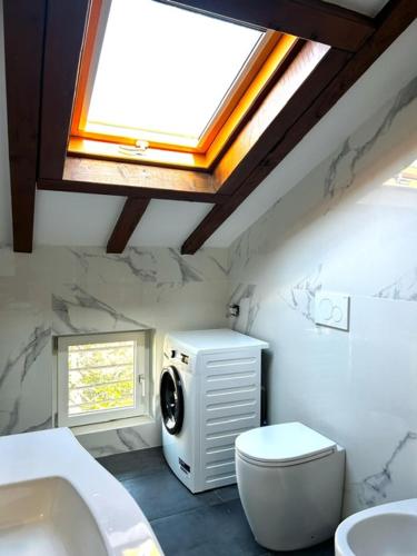 a bathroom with a toilet and a sink and a skylight at CARDAHAUSe Via DANTE 12 in Cogliate