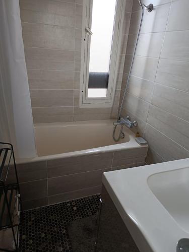 a bathroom with a tub and a sink and a mirror at Bel Appartement panoramique in Arâches-la-Frasse