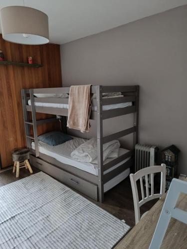 a bunk bed in a room with a table at Bel Appartement panoramique in Arâches-la-Frasse