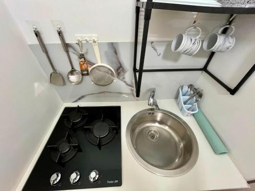 a kitchen sink with pots and pans and a stove at B&B Tribale in Ercolano