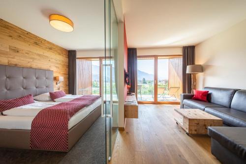 a hotel room with a bed and a couch at Hotel Der Heinrichshof in Lagundo