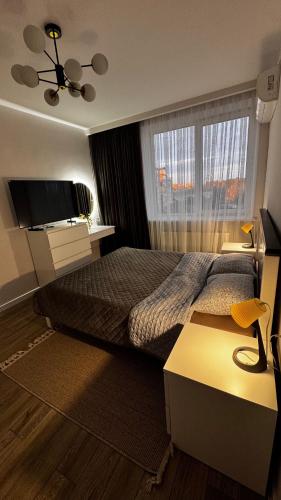 a hotel room with a bed and a television at Compass Apartments Елітний Житловий комплекс in Chernivtsi