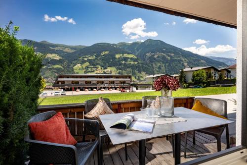 a table on a balcony with a view of mountains at Apart Denise in Fügen