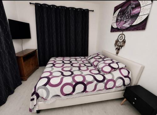 una camera da letto con un letto con un piumone viola e bianco di Worgot a Monthermé