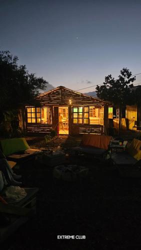 a house lit up at night with the lights on at extreme park in Deir Ḥannā