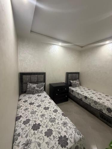 a bedroom with two beds and a dresser in it at appart plage in M'diq