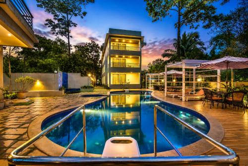 a swimming pool in front of a building at Ramatan Resort in Vagator