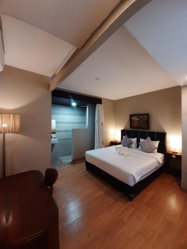 a bedroom with a large white bed in a room at Margot Guest House in Sanur
