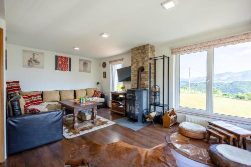 a living room with a couch and a table and a fireplace at Utopia Mountain resort Bjelasnica in Bjelašnica