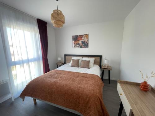 a bedroom with a large bed and a window at DOMITYS - Les Ambres in Cognac