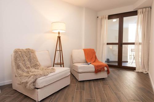 two chairs and a lamp in a living room at Xena Pueyo by BeValle in Panticosa
