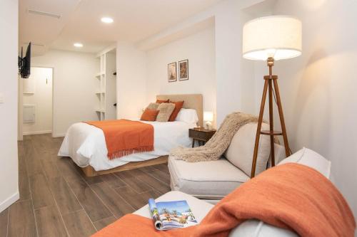 a bedroom with two beds and a chair and a lamp at Xena Pueyo by BeValle in Panticosa