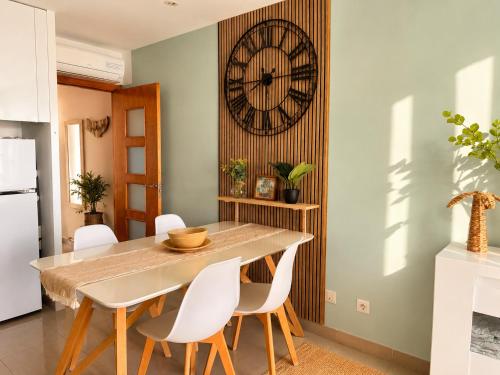 a dining room with a table and a clock on the wall at Almadrava Beach in Roses