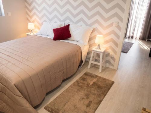 a bedroom with a large bed with two lamps and a rug at Charming House in Requião with Shared Pool in Requião