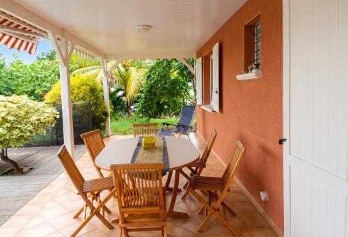 a dining room with a table and chairs on a patio at Villa ensoleillée aux Anses-d'Arlet avec piscine privée in Les Anses-dʼArlets