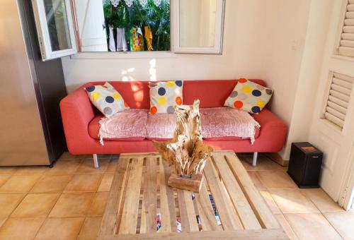 a living room with a red couch and a table at Villa ensoleillée aux Anses-d'Arlet avec piscine privée in Les Anses-dʼArlets
