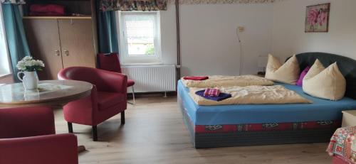 a bedroom with a bed and a table and a chair at Pension Pencik in Kurort Altenberg