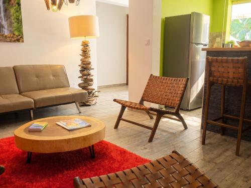 a living room with a couch and chairs and a table at Appartement spacieux avec jardin et piscine à Lamentin, 97 m² in Lamentin