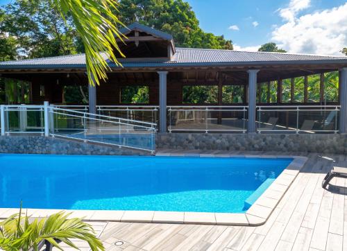 a house with a swimming pool and a pavilion at Appartement spacieux avec jardin et piscine à Lamentin, 97 m² in Lamentin