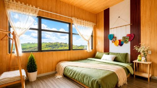 a bedroom with a bed and a large window at LaLa Hill in Ấp Kim Thạch