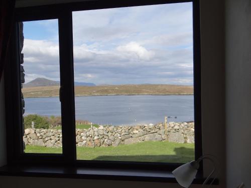 a window with a view of a large body of water at Cill Cottage in Roundstone