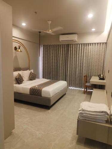 a hotel room with a bed and a window at Umbrellaa Hotels in Ahmedabad