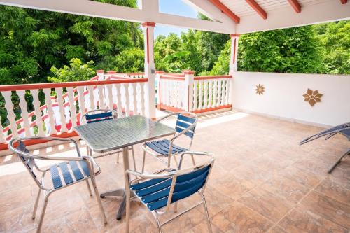 a patio with a table and chairs on a deck at Maison vue sur mer à Vieux-Habitants + Terrasse in Vieux-Habitants