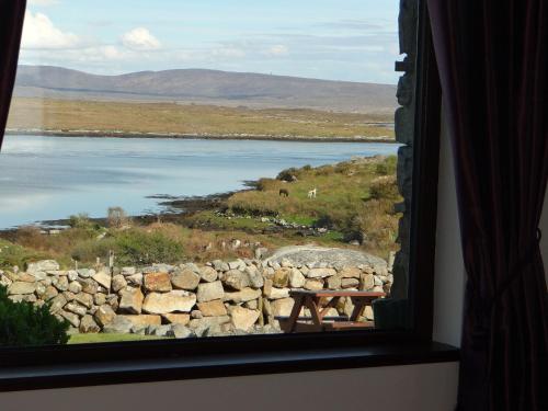 a window with a view of a body of water at Cill Cottage in Roundstone