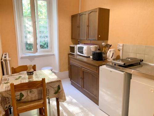 a small kitchen with a table and a microwave at Appartement cosy à Néris-les-Bains, 20 m², balcon avec vue in Néris-les-Bains