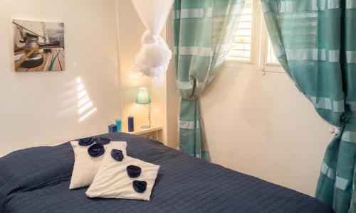 a bedroom with a blue bed with blue curtains at Appartement spacieux au Vauclin avec piscine privée in Le Vauclin