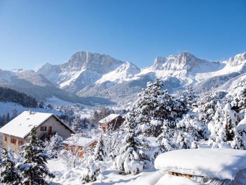 a snowy mountain view of a village with snow covered trees at Appartement chaleureux à Gresse-en-Vercors 43 m² vue montagne in Gresse-en-Vercors