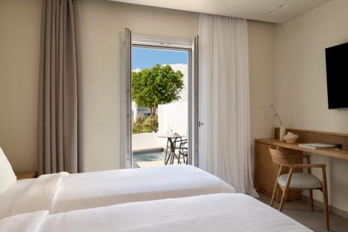 a hotel room with a bed and a sliding glass door at Naxos Resort in Naxos Chora