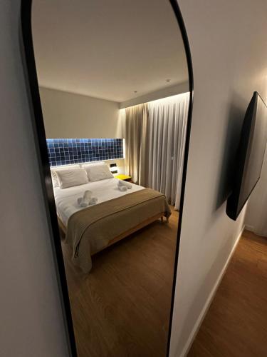 ein Schlafzimmer mit einem Bett und einem Spiegel in der Unterkunft Aetheria resort in Samothráki
