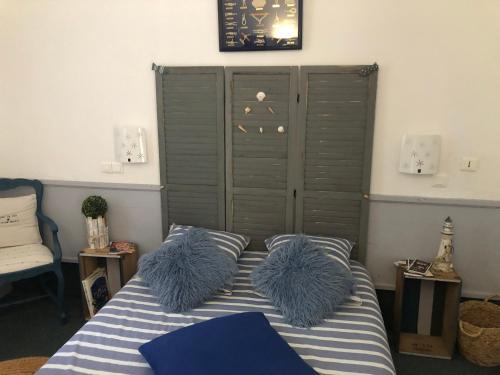 a bedroom with a bed with two blue furry pillows at Chambre la paix verte in Payrac