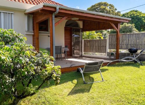 a pergola with a deck in a yard at Studio charmant à Sainte-Anne, 23 m², piscine partagée in Sainte-Anne