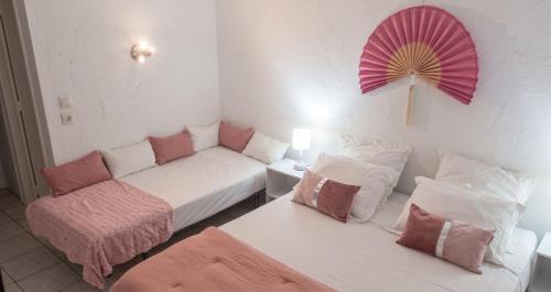 a living room with a couch and a pink fan at Studio romantique à Saint-François - 25 m² avec piscine in Saint-François