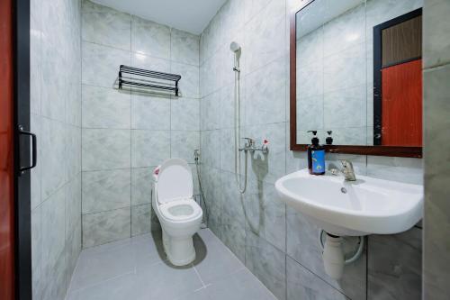 a bathroom with a toilet and a sink at Sans Hotel Sedana Batam in Nagoya