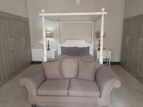 a bed room with a couch in front of a bed at Unitas Park B&B in Vereeniging