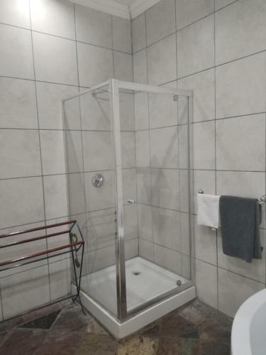 a shower with a glass door in a bathroom at Unitas Park B&B in Vereeniging