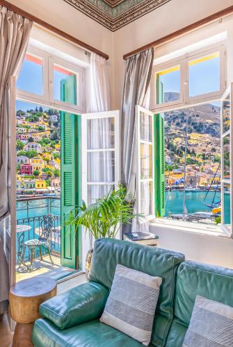a living room with a green couch and windows at "LOS" 2 Neoclassic Harbour View in Symi
