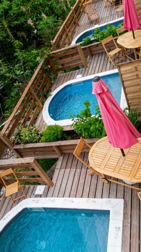 a wooden deck with chairs and a swimming pool at Maison charmante Le Moule + piscine in Le Moule
