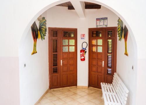 a hallway with two wooden doors and a bench at Appartement accueillant au Robert avec balcon et jardin in Le Robert
