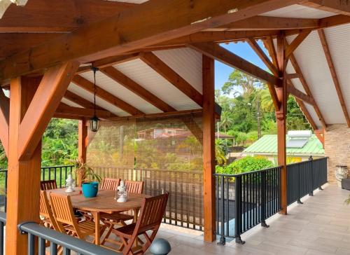 a wooden pavilion with a table and chairs on a patio at Studio cosy à Capesterre-Belle-Eau avec terrasse in Capesterre-Belle-Eau