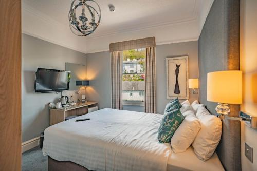 a bedroom with a bed and a tv and a window at Ambleside Fell Rooms in Ambleside