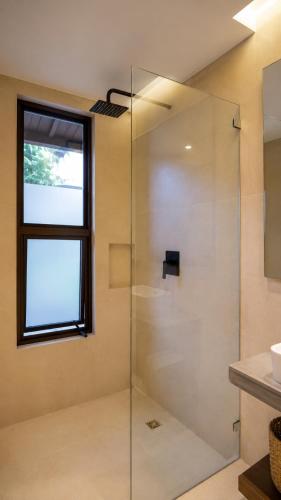 a glass shower in a bathroom with a window at Hotel Alto Monte Hacienda & Spa - Only Adults in Chiguirí Arriba