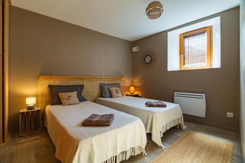 a bedroom with two beds and a window at Gîte La Peyrolle in Aouste-sur-Sye