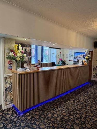 a lobby with a counter with flowers on it at Bournemouth Sands Hotel in Bournemouth