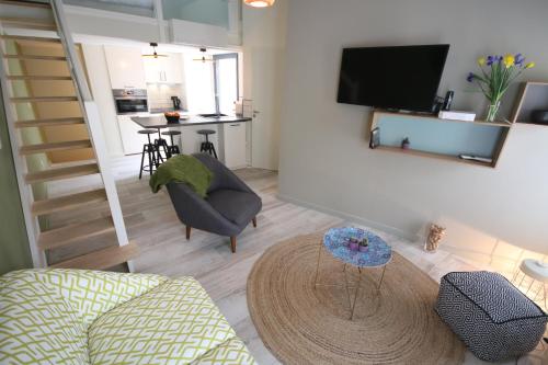 ボルドーにあるLa Villa Verteのリビングルーム(ソファ、椅子、テレビ付)