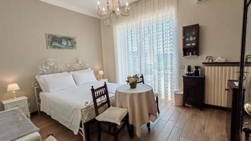 a bedroom with a white bed with a table and a window at La Casatella Agriturismo in Alba