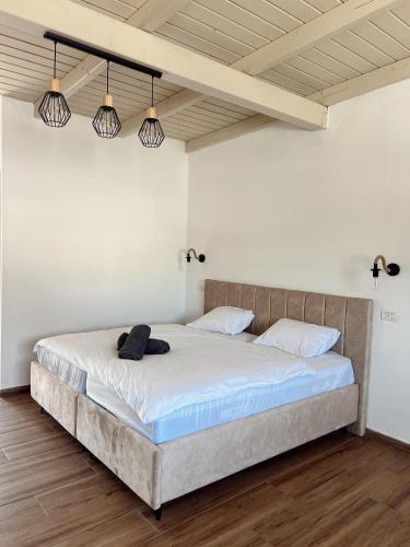 a bedroom with a large bed with white sheets and lights at בצלי-ה in Safed